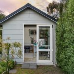 A small shed with a door open in a garden.
