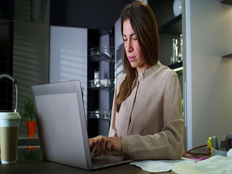 Focused Professional Working on Laptop at Home