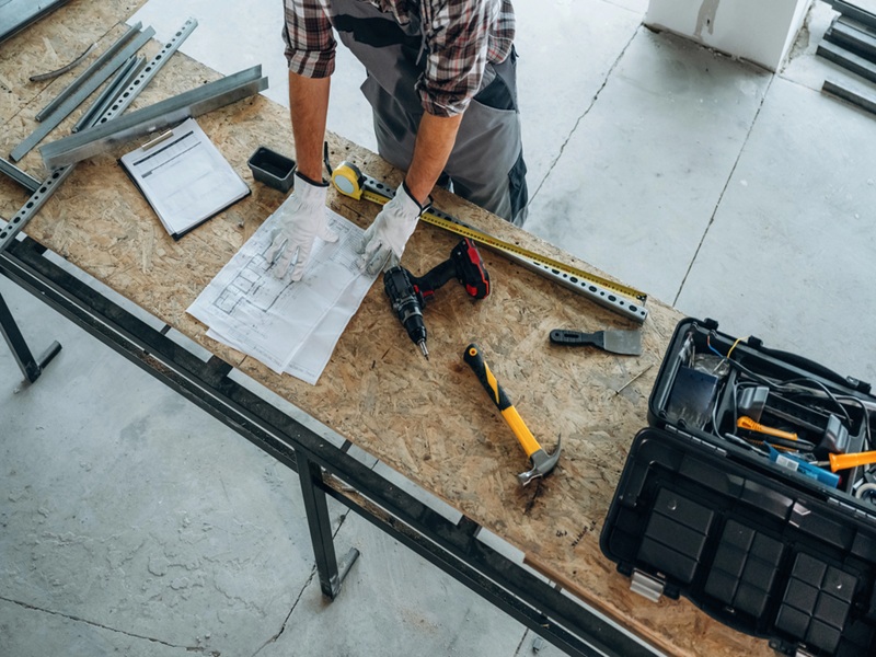 Focused, tools. Close up view of worker that is renovating unfinished room Focused, tools. Close up view of worker that is renovating unfinished room