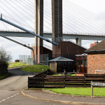 Massive Suspension Bridge Support Towers over Residential Street