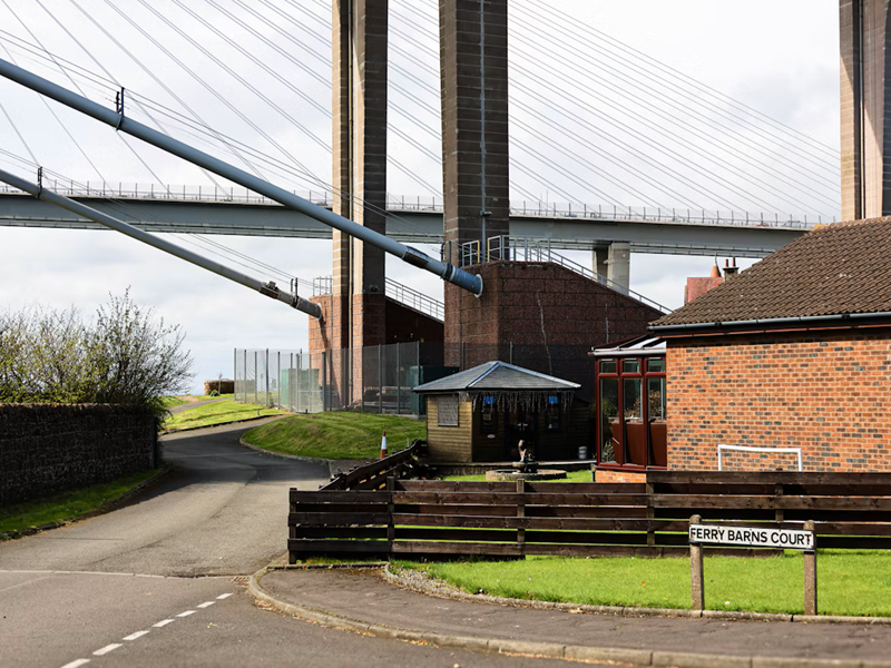 Massive Suspension Bridge Support Towers over Residential Street Massive Suspension Bridge Support Towers over Residential Street