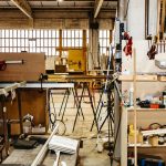 Organized metal window frames stored vertically inside industrial workshop