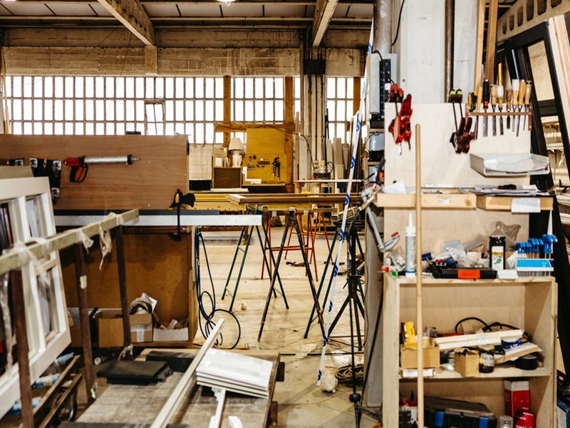 Organized metal window frames stored vertically inside industrial workshop