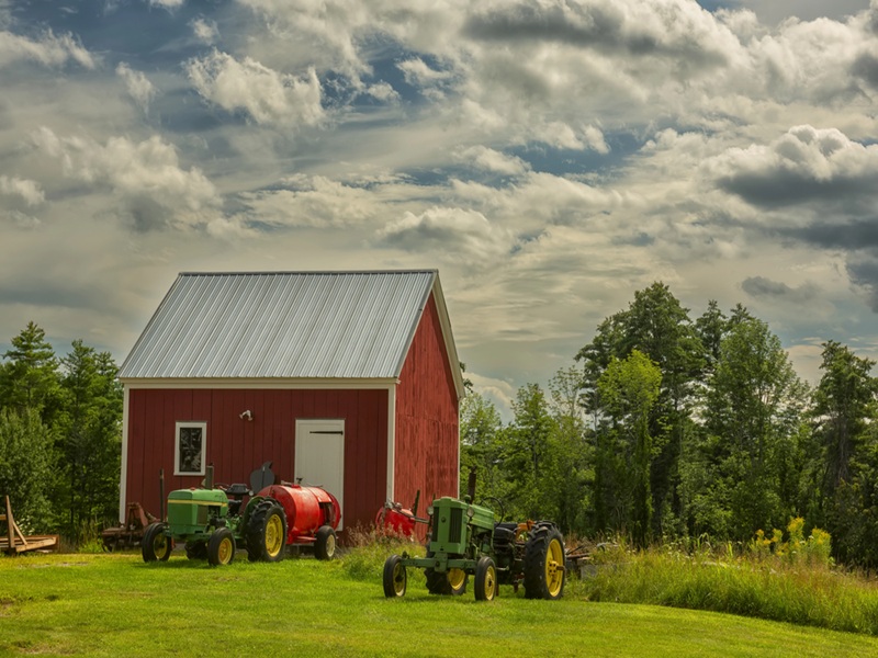 Small farm shed with machinery outside