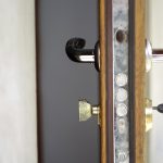 Defocus half opened door to a living room. Door handle, door loc
